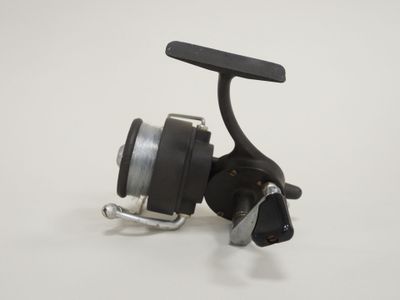 a close up of a fishing reel on a white surface