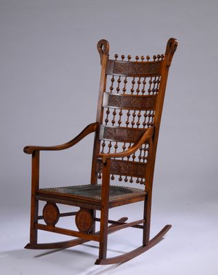 un vieux fauteuil à bascule avec une structure en bois et une assise en cuir