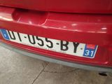 the rear end of a red car with a number plate on it