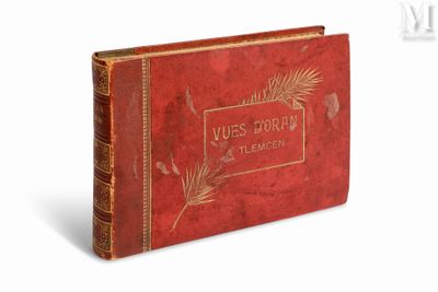 un vieux livre à la couverture rouge posé sur une surface blanche