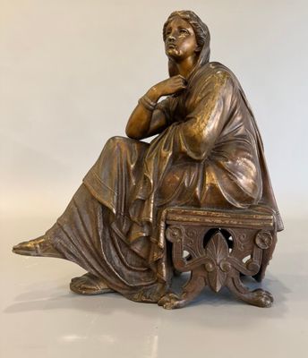 une photo d'une statue en bronze représentant une femme assise sur un banc