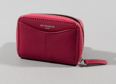 the pink leather wallet is open and has a zipper on the front