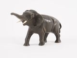 une figurine d'éléphant posée sur une surface blanche