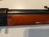 the rifle is sitting on the table ready to be auctioned