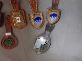 four spoons with badges on them hanging on a wall