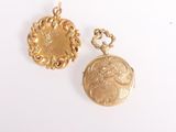 deux pendentifs en forme de pièces d'or sur une surface blanche, avec un fond blanc