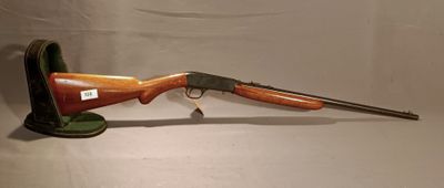 a rifle that is on a stand on a white surface