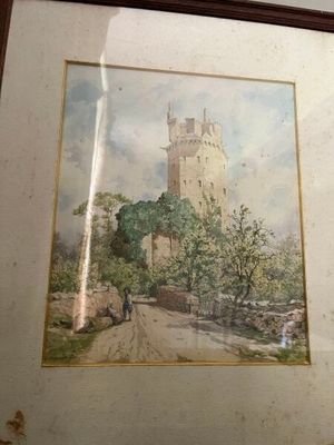tableau représentant un château, encadré et accroché au mur d'une pièce