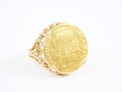 a close up of a gold coin ring on a white surface