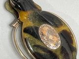 a picture of a broochee broochee with a silver plate on it