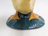 a yellow and blue vase with a bird on top of it