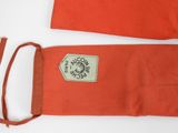 an orange bag with a label on it sitting on a white surface