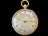 a gold pocket watch with roman numerals on the face