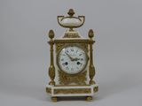 une horloge blanche et dorée posée sur une table