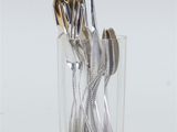 silverware in a clear glass with a gold spoon and fork in it