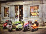 plusieurs trottinettes garées devant un immeuble, avec un magasin en arrière-plan