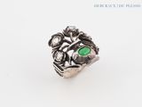 Gros plan sur une bague contenant une pierre verte