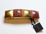 une barrette dorée et rouge, avec une étiquette attachée
