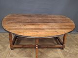 a wooden table with a circular top on a wooden floor