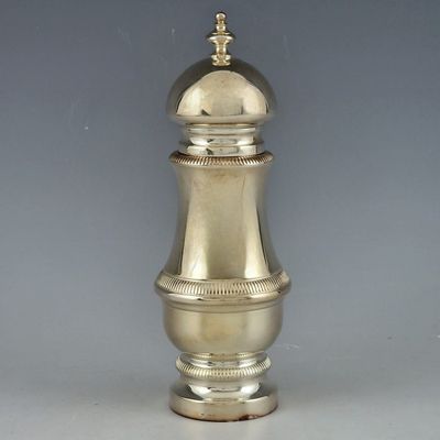 une poivrière en argent avec un couvercle doré