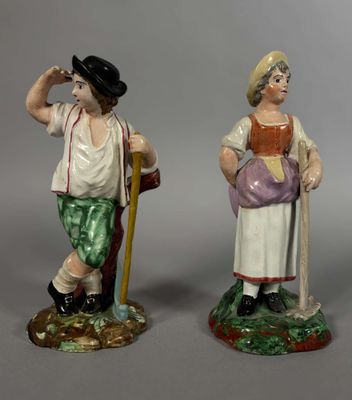 paire de figurines en céramique représentant un homme et une femme, l'un tenant une canne