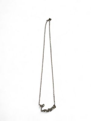 a close up of a necklace on a white surface with a white background
