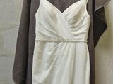 a white dress hanging on a hanger in a room