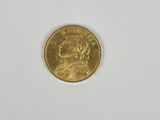 gros plan d'une pièce d'or sur une surface blanche