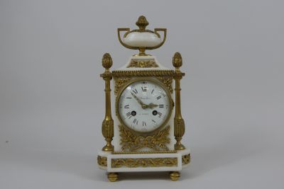 une horloge blanche et dorée posée sur une table