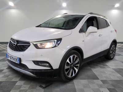 a white buick suv parked on a checkered floor in a garage