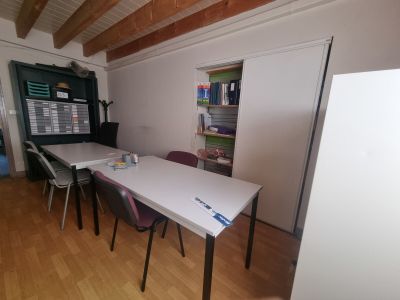 une table et des chaises blanches dans une pièce avec un parquet