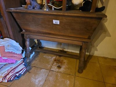 une armoire en bois surmontée d'un miroir, à côté d'une pile de vêtements