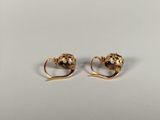 a pair of gold earrings with a heart shaped design