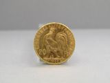 a close up of a gold coin on a white surface