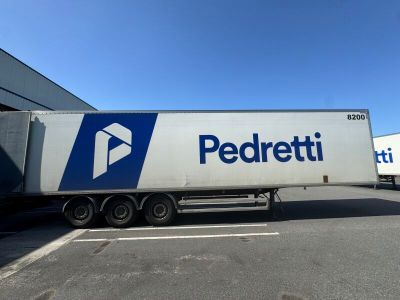 the truck is parked in front of the building with a blue and white logo on it