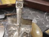 a silverware set on a table with a knife, fork, spoon, and knife rest