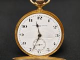 une montre de poche antique sur une surface noire avec un fond noir