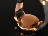 a close up of a watch on a black surface