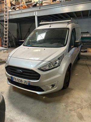La camionnette blanche est garée dans le garage de l'immeuble.