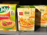 three boxes of cereal sit on a shelf in a store