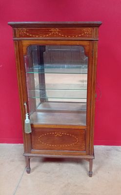 une vieille vitrine en bois surmontée d'une porte vitrée