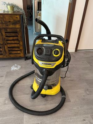 un aspirateur jaune et noir posé sur un parquet