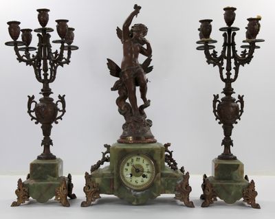 trois bougies et une horloge posées sur une table