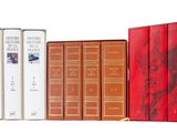 plusieurs livres sont alignés sur une surface blanche