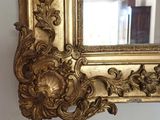 a gold mirror hanging on a wall in a room