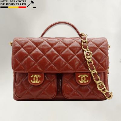 a brown chanel bag with a gold chain hanging from it