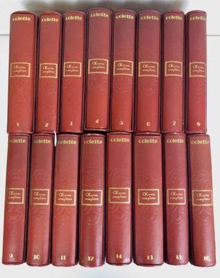douze livres rouges alignés en rangées sur une surface blanche