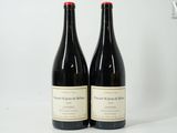 deux bouteilles de vin rouge posées sur une table blanche