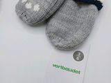a pair of gray and white knitted mittens on a table