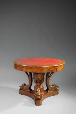 une table ronde avec un piètement en bois et un plateau rouge